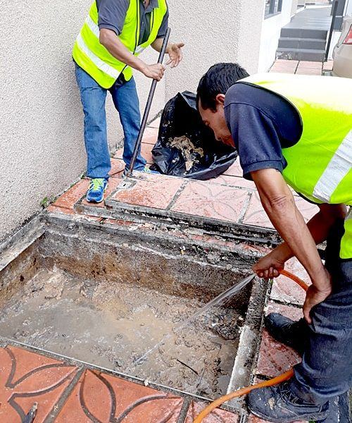 Technician servicing an underground grease trap